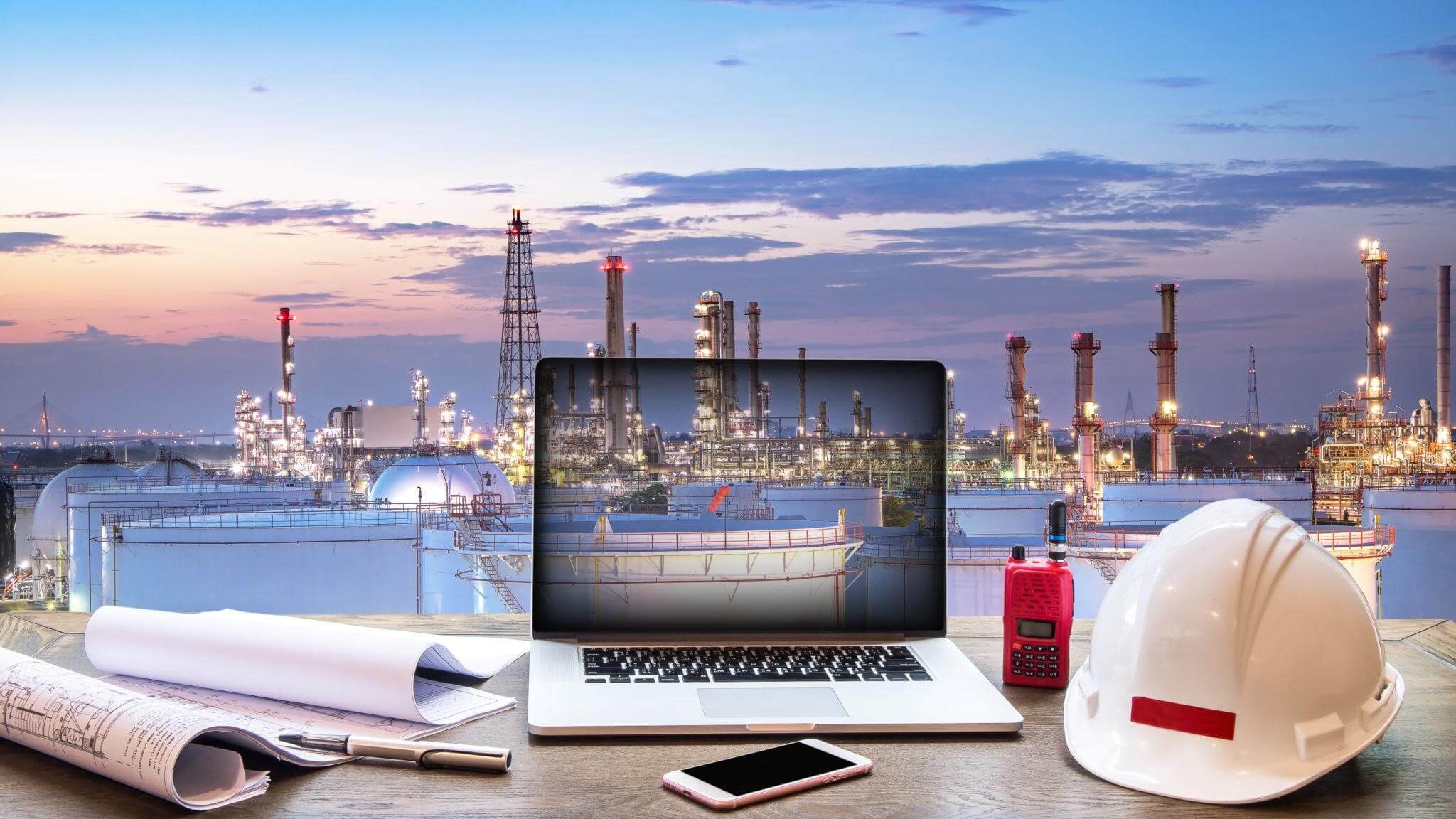 Computador e equipamentos de trabalho em cima de uma mesa, com uma cidade ao fundo