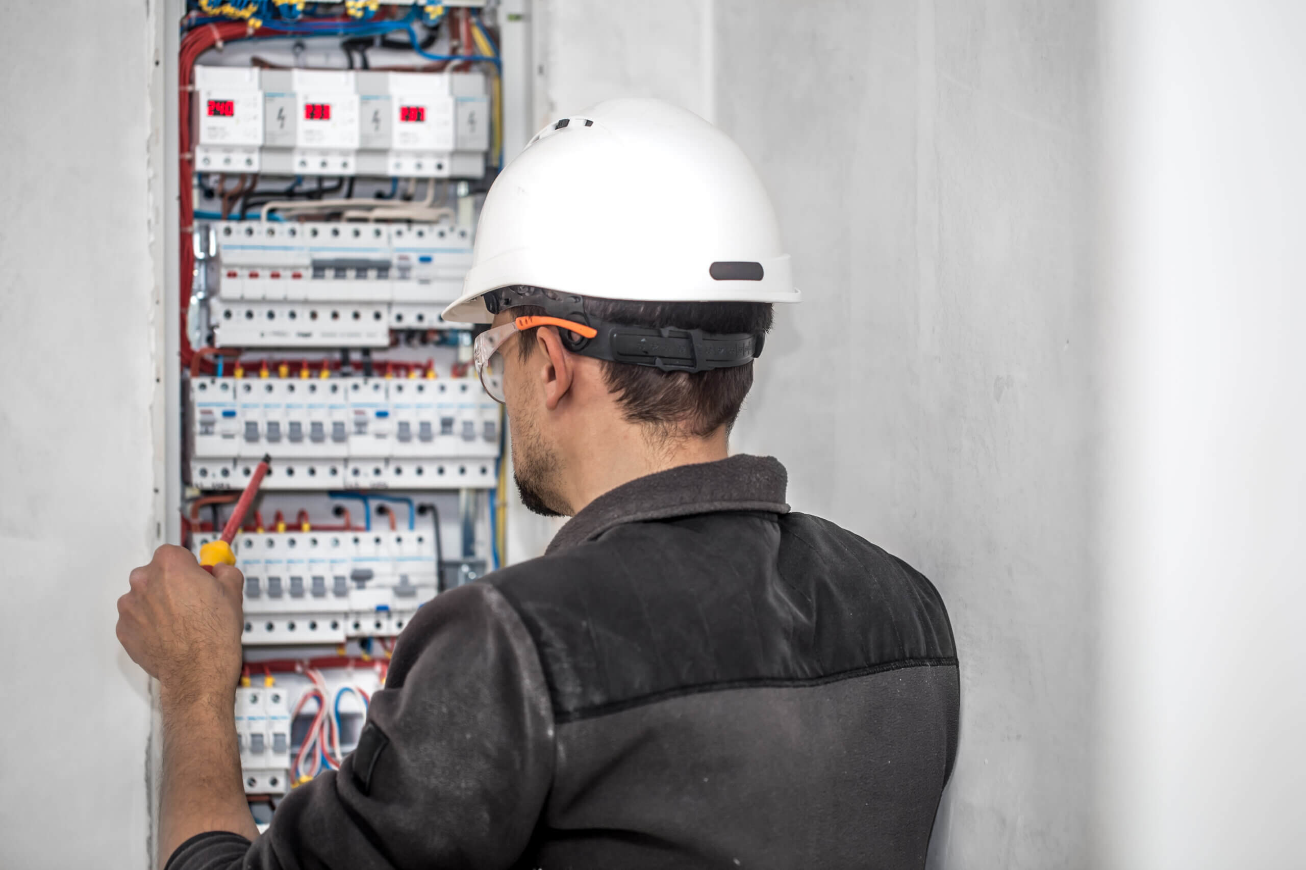 homem trabalhando em um painel elétrico