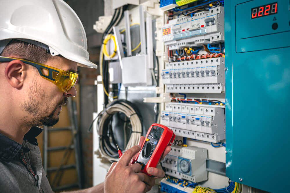 Técnico elétrico trabalhando em um painel de média tensão